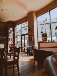 Interior view of cafe with leather chairs and tables.