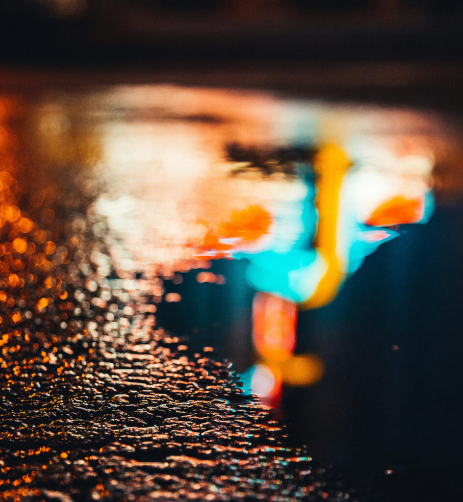 Photo of a neon sign reflected in a puddle at night by Ruvim | Pexels